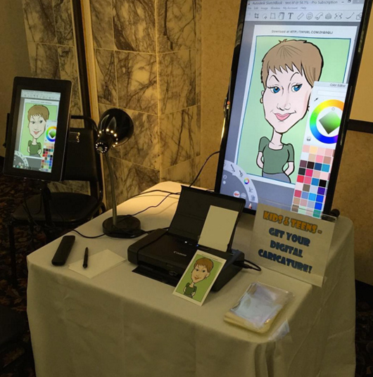 The digital caricature setup, including the tablet, printer and display screen.